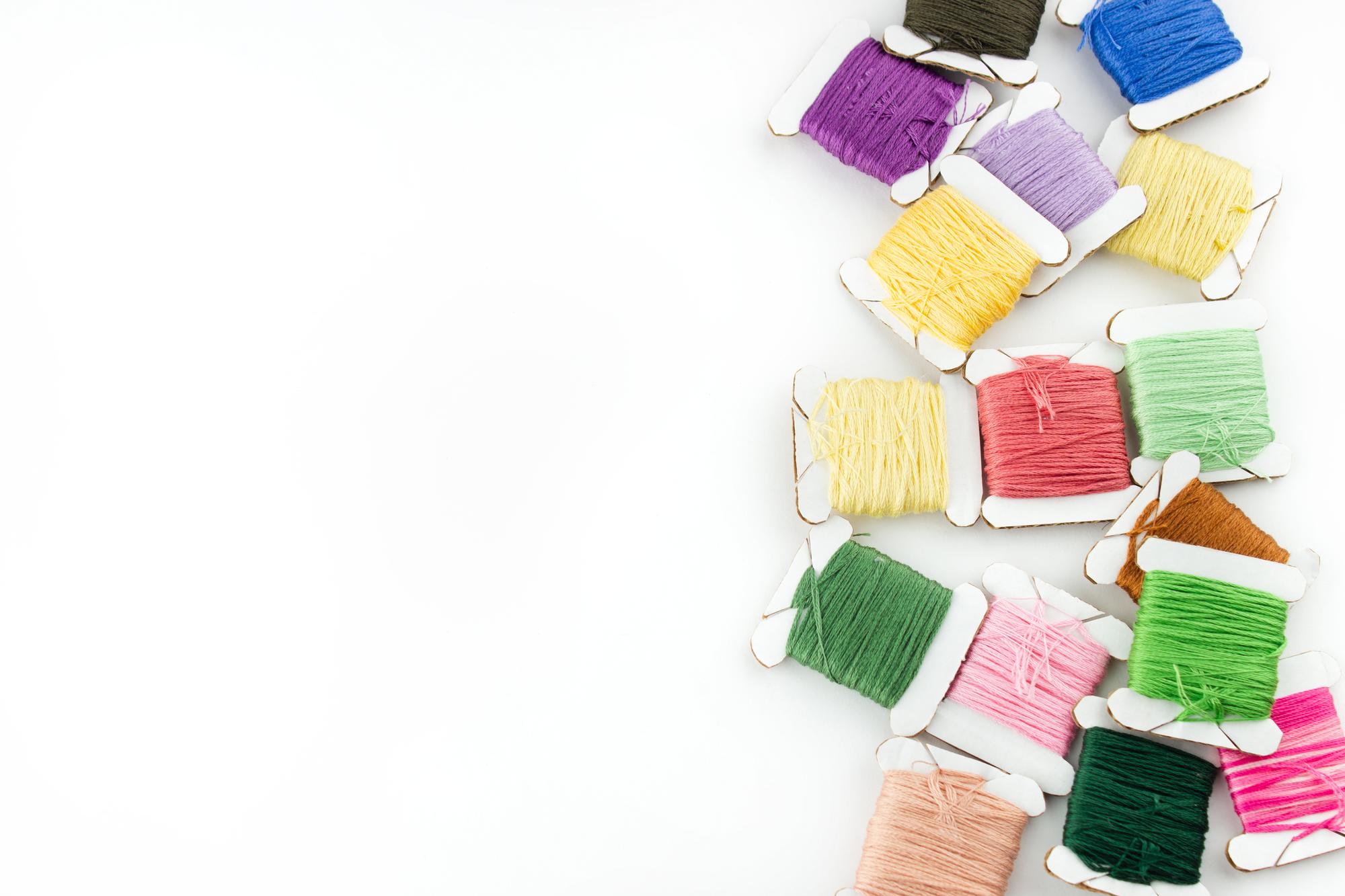 Three fabric swatches and threads laid out